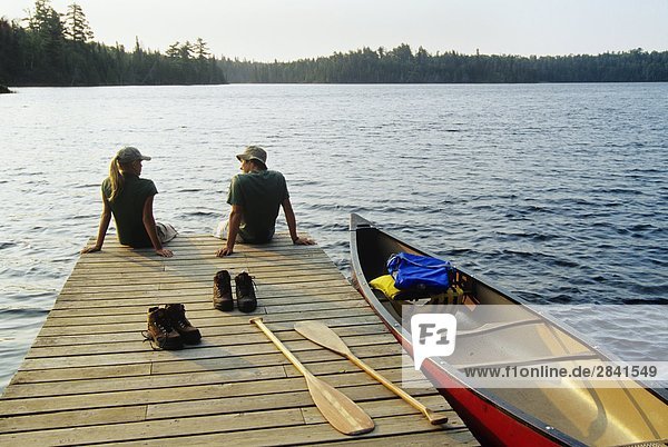 Teenagers on dock  Lyons Lakes  Whiteshell Provincial Park  Manitoba  Canada.