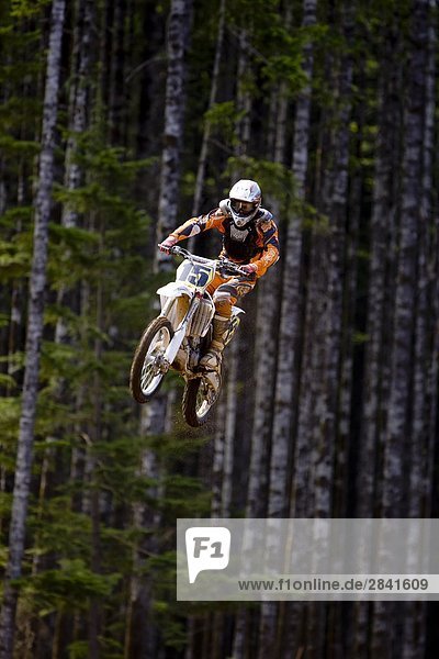 Motocross rider getting big air off of large double jump in motocross Race in Campbell River  Vancouver Island  British Columbia  Canada