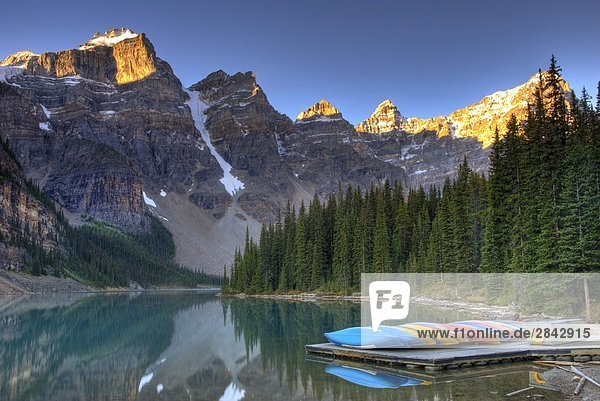 Frosty canoes sit on the dock at sunrise at Moraine Lake in the Valley of the Ten Peaks. Banff National Park  Alberta  Canada.