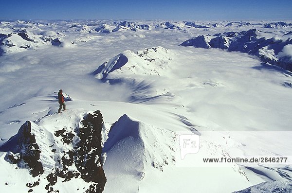 Man atop the summit of Mount Garibaldi  Garibaldi Provincial Park  near Squamish  British Columbia  Canada.