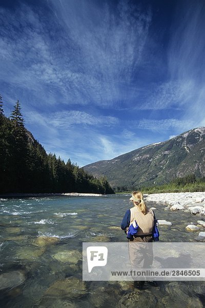 Lady flyfisher  fishing for steelhead  Dean river  Central Coast  British Columbia  Canada.