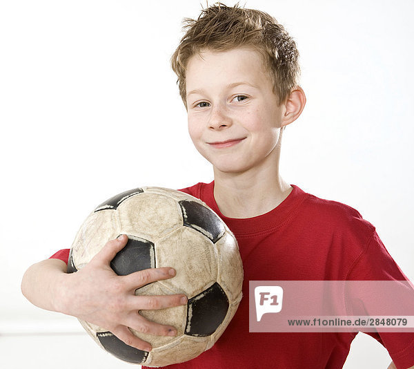 Junge hält Soccer Ball und lächelnd