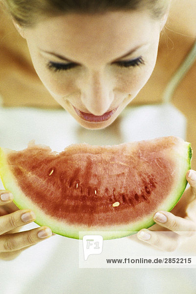Frau isst Wassermelonenscheibe
