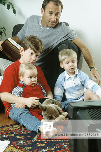 Vater und drei Söhne beim gemeinsamen Fernsehen