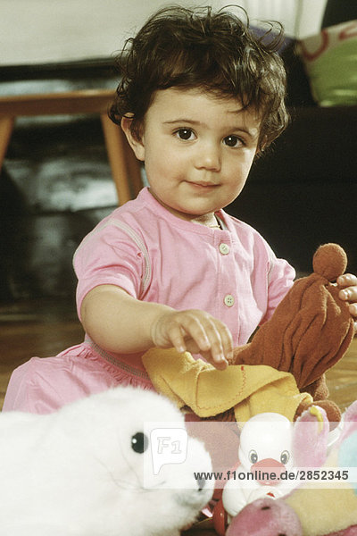 Kleines Mädchen sitzend mit Spielzeug  Portrait