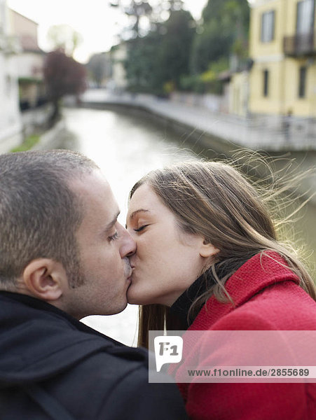 Young couple kissing by river