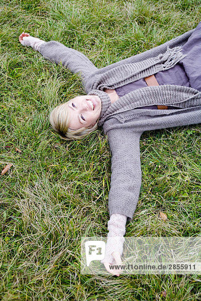 Frau auf dem Rücken auf Gras liegend