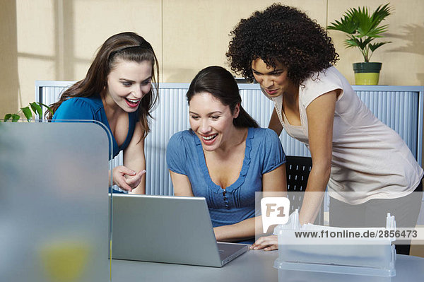 Gruppe junger Frauen mit Laptop am Schreibtisch