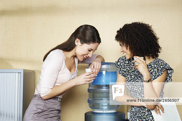 Zwei Frauen lachen am Wasserspender