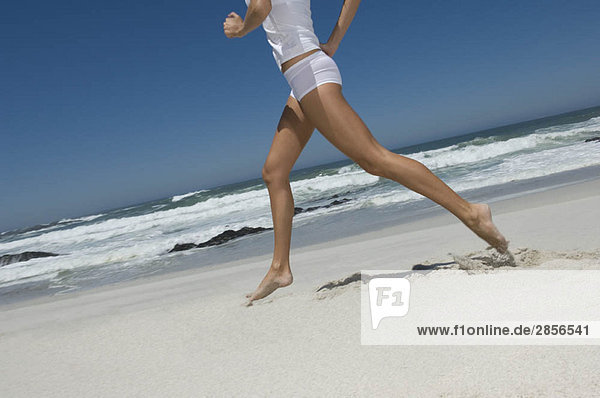 Weibliches Laufen am Strand