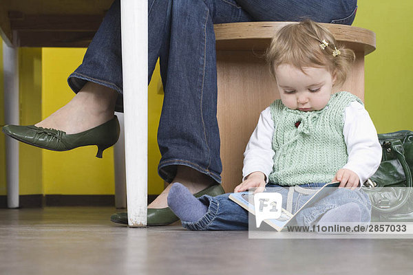 Young girl on floor with book