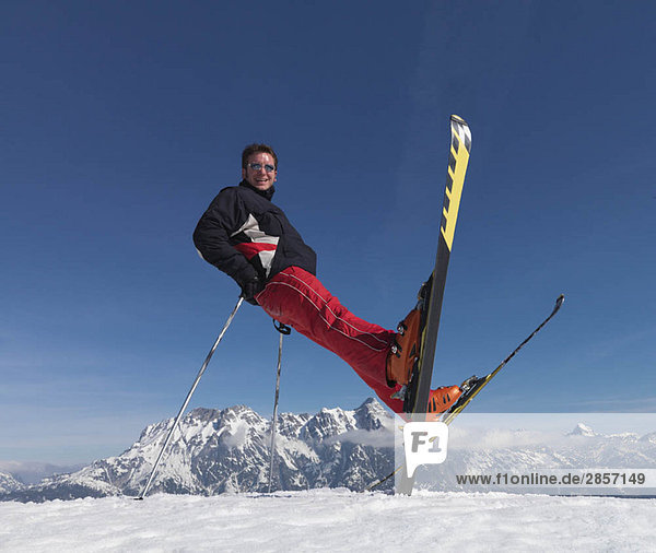 Man balancing on skis and skiing poles