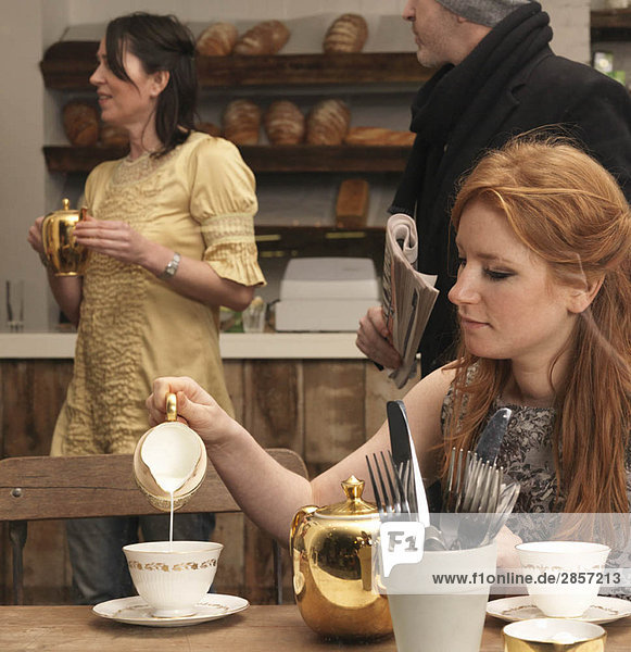 Junge Frau beim Tee im Café