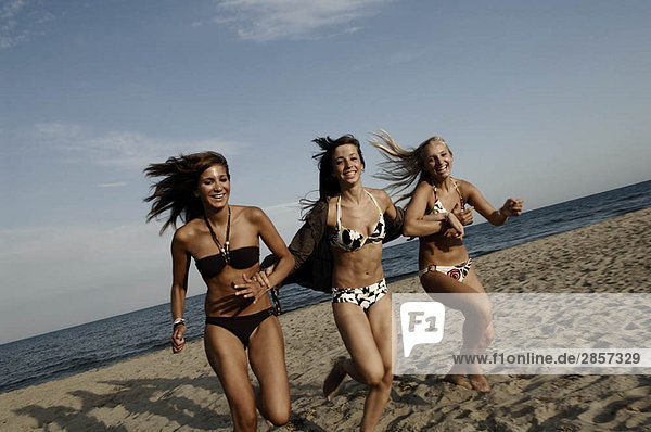 Girl teenagers running on the beach