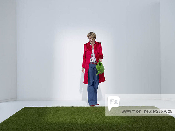 Frau in grünem Bürobewässerungsrasen
