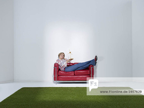 Frau liegt auf Sofa mit Windrad