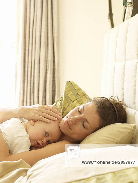Mutter hält Baby im Bett