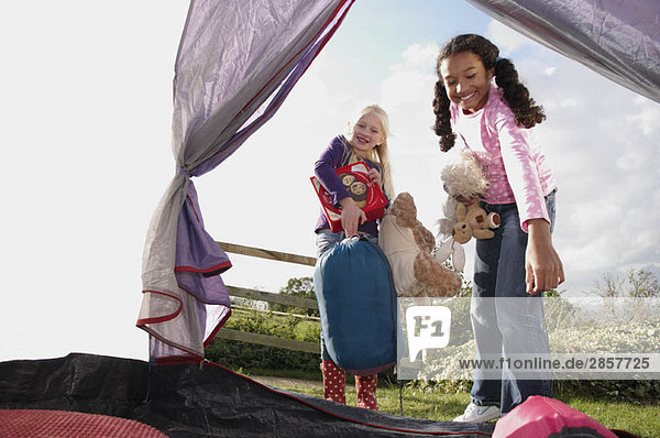 Mädchen stellen Schlafsäcke ins Zelt