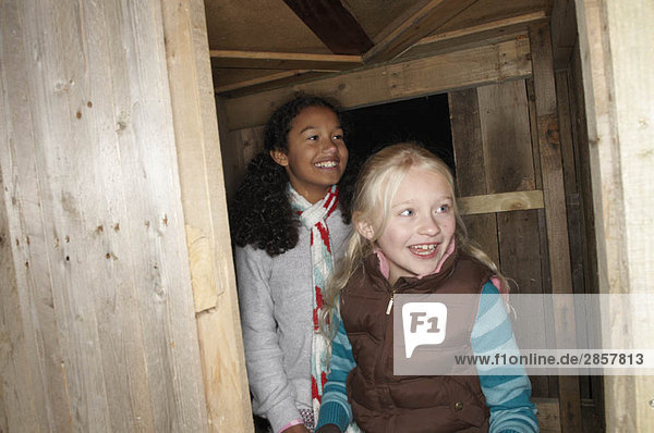 Zwei junge Mädchen betreten das Baumhaus