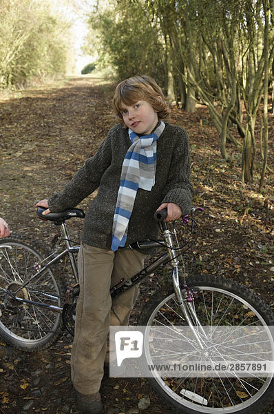 Junge mit Fahrrad auf dem Landweg