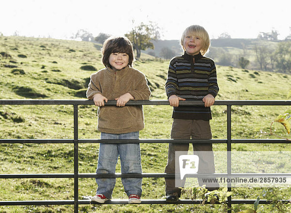 Zwei kleine Jungen am Tor auf dem Lande