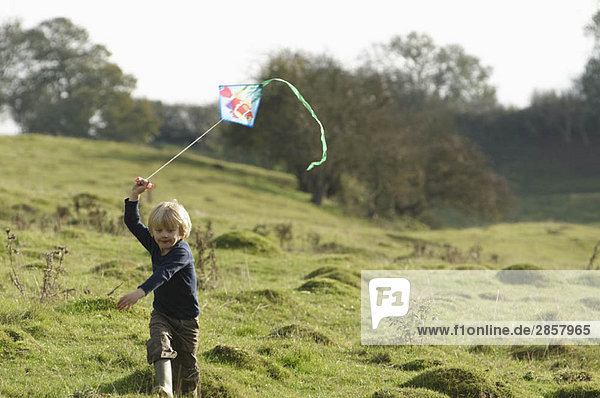 Young boy running with kite