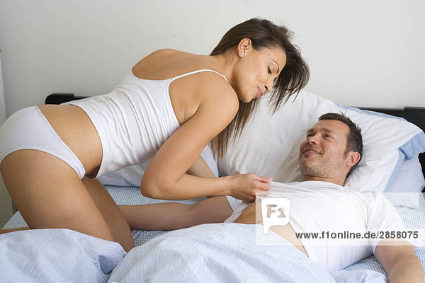 Young couple at home relaxing in bed