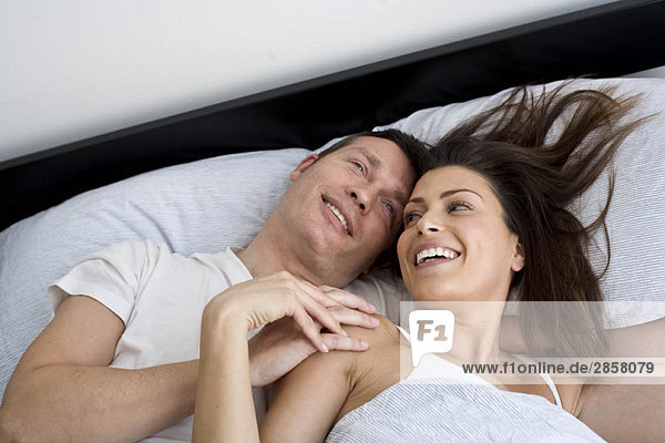 Junges Paar entspannt im Bett