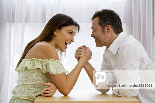 Mann und Frau beim Armdrücken