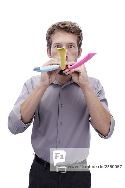 Junger Mann mit Partygebläse im Mund,  Portrait