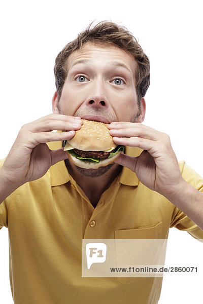 Junger Mann isst Hamburger,  Portrait,  Nahaufnahme