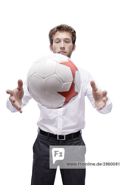 Junger Mann spielt mit Fußball  Portrait