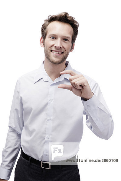 Young man making hand gesture  smiling  portrait