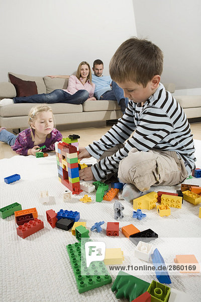 Family relaxing at home  children playing with building bricks