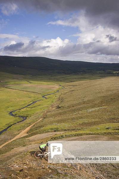 Island  Mann Mountainbike durch hügelige Landschaft
