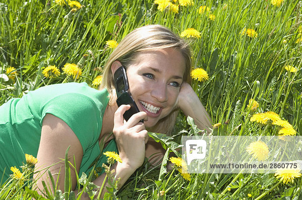 Austria  Salzburger Land  woman in meadow using phone
