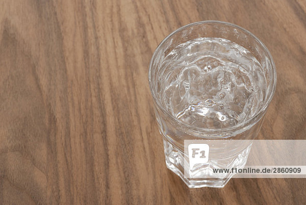 Wasserglas auf Holztisch  erhöhte Ansicht