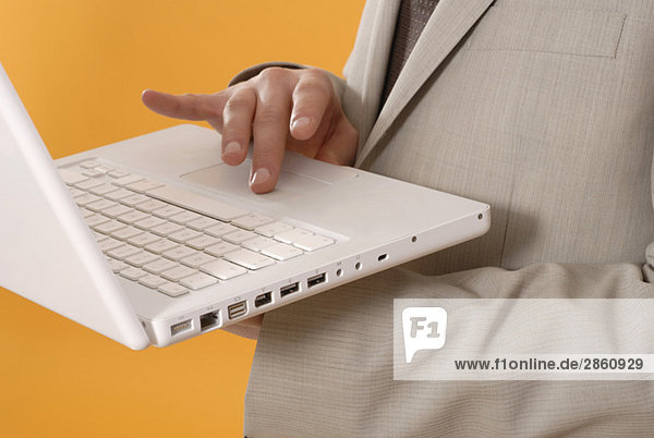 Businessman using laptop  middle section  close up