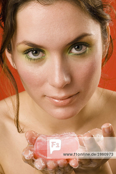 Young woman holding cake of soap  close up