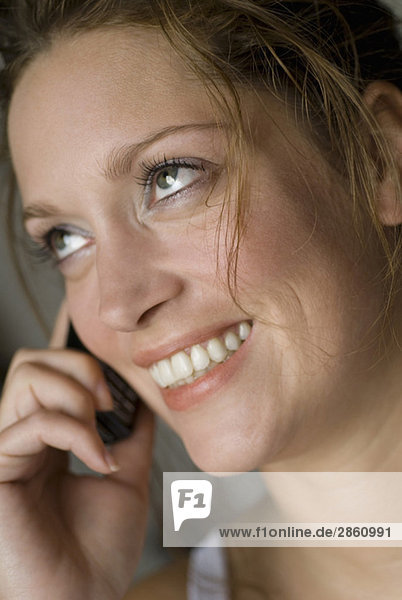 Young woman using mobile phone  smiling  close up