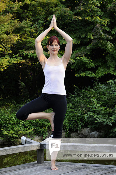 Junge Frau  die Yoga praktiziert  Hände über dem Kopf