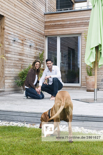 Germany  Bavaria  Munich  couple on terrace in front of house with dog