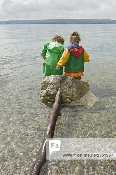 Deutschland Baden-Württemberg Bodensee Kinder (3-5) im Wasser stehend Rückansicht