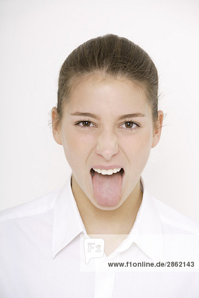 Young woman (16-17) poking her tongue out  portrait