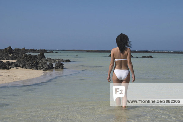 Spanien  Lanzarote  Orzola  Junge Frau im Bikini  Rückansicht