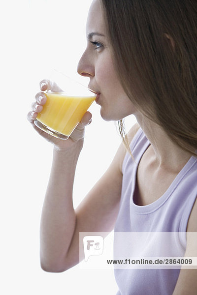 Junge Frau trinkt Orangensaft  Portrait  Seitenansicht  Nahaufnahme