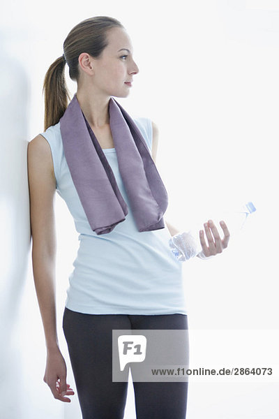 Young woman holding water bottle and towel  portrait