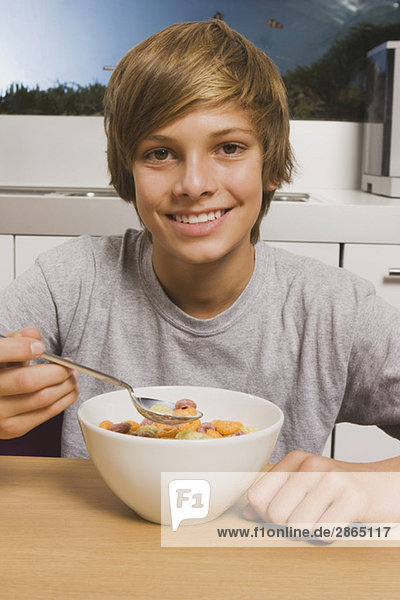 Teenager Junge (14-15) mit Müsli zum Frühstück  lächelnd  Portrait