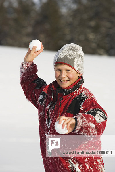 Austria  Steiermark  Boy (12-13) holding snowball  smiling  portrait