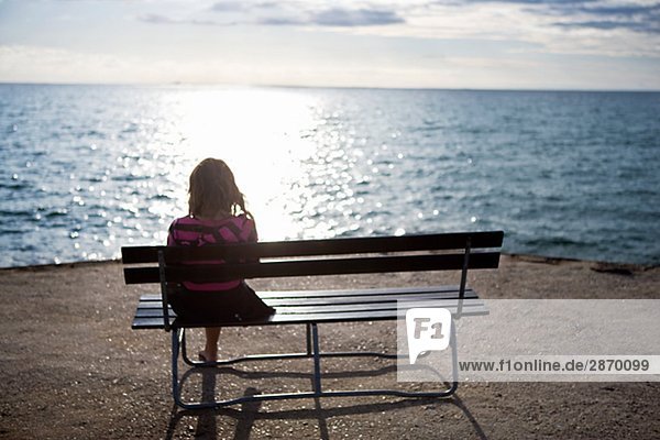 Ein Mädchen sitzen auf einer Bank Oland Schweden.